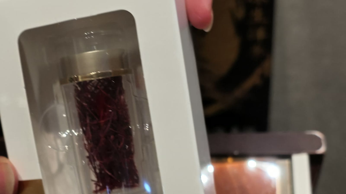 A small glass vial of deep red Iranian saffron threads held up in a gift box at the Fosetter counter.