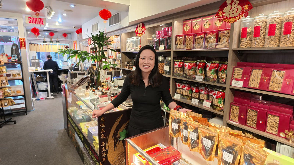 Carmen smiling at the counter of Fosetter, with shelves of Canadian ginseng behind her.