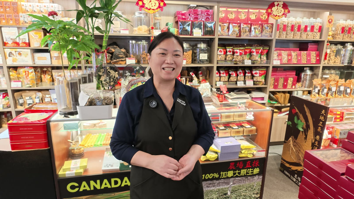 A Fosetter staff member smiling behind the counter, with shelves of ginseng and gift boxes behind her.