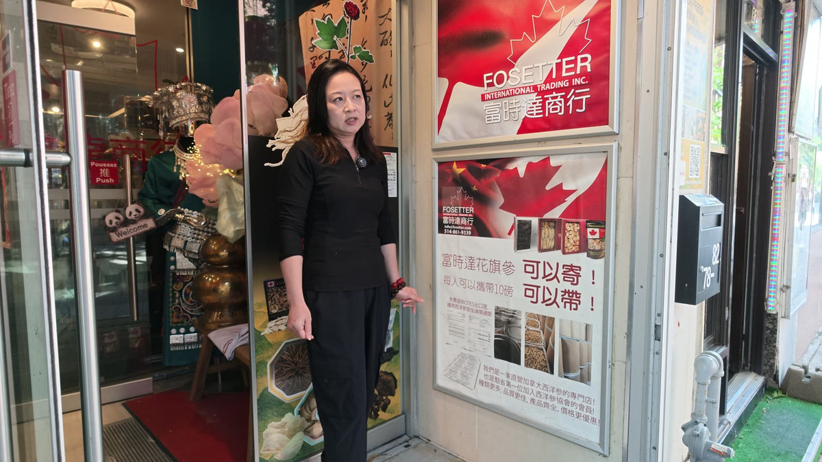 Carmen standing at Fosetter's front door next to the shop's red sign.